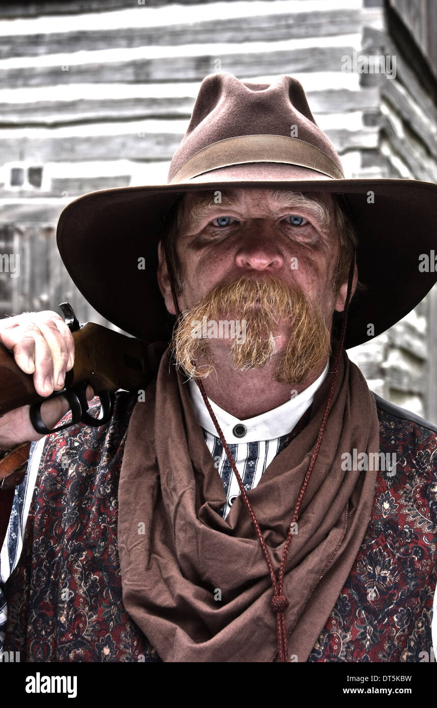 Old West cowboy in front of a log cabin Stock Photo - Alamy