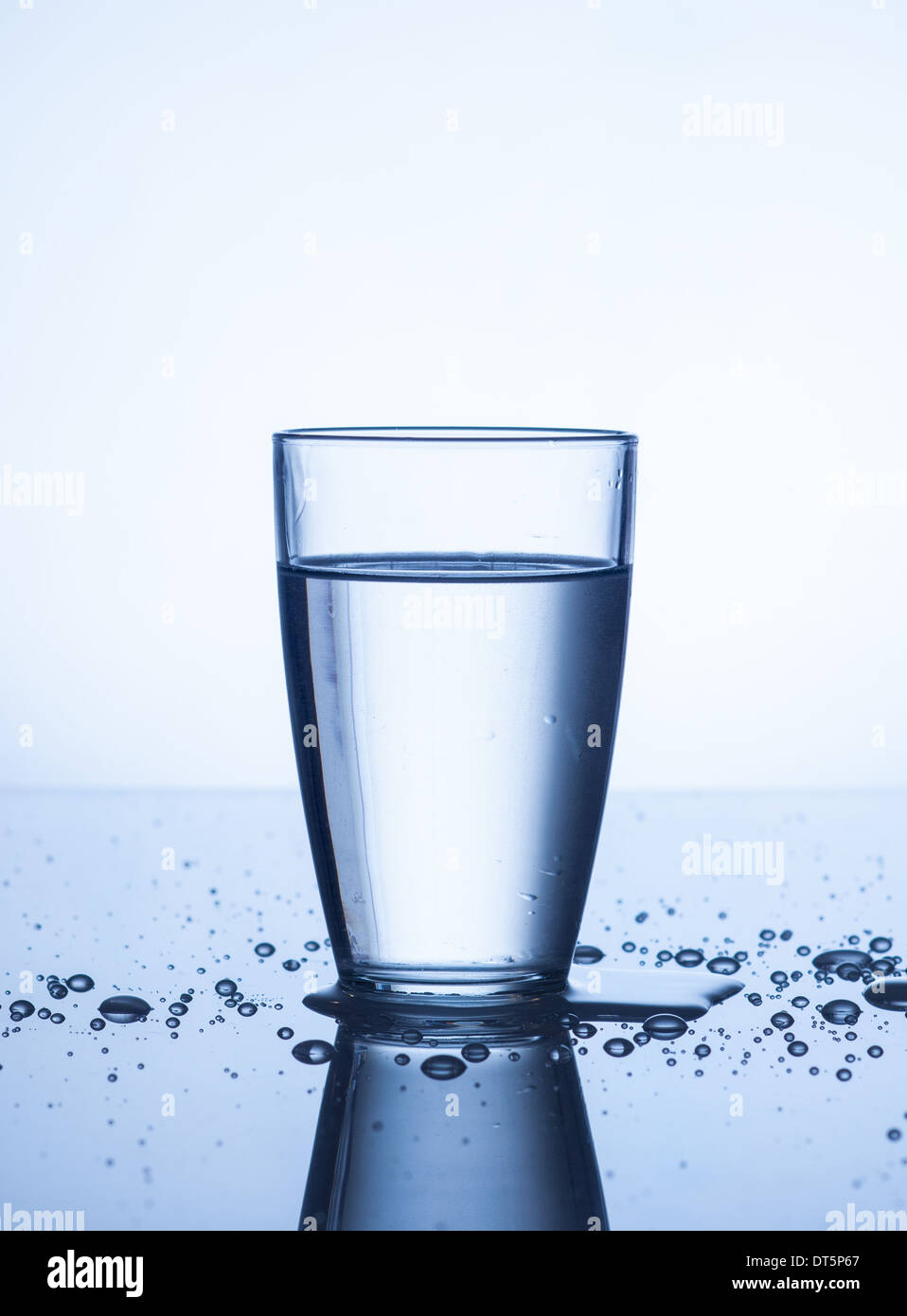Glass of water with drops on light background Stock Photo