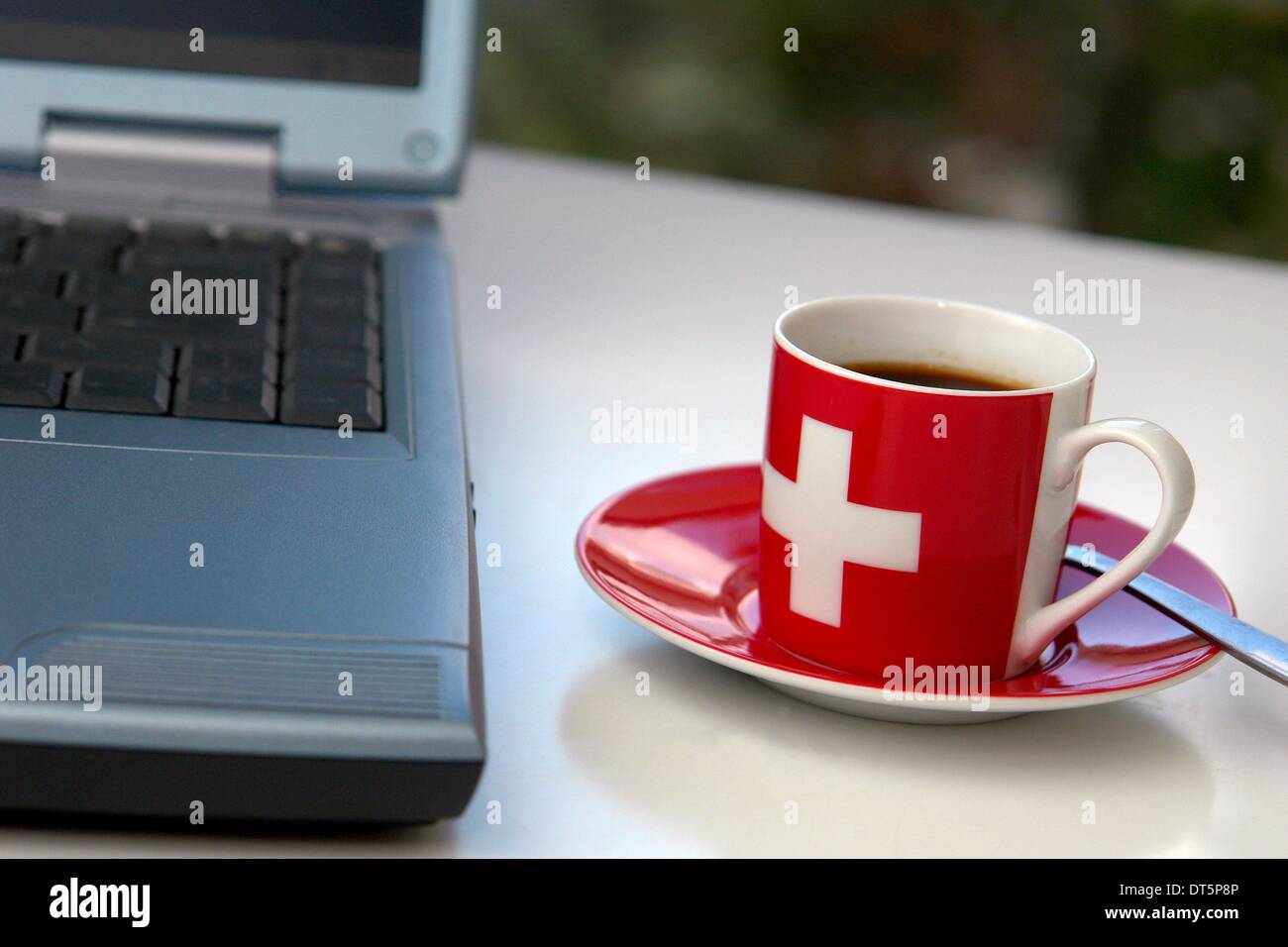 Automated translation: Icon image on studying in Switzerland with a laptop computer and cup of coffee with the Swiss cross. Bern, Bern, Switzerland, 01.06.2007 . Stock Photo