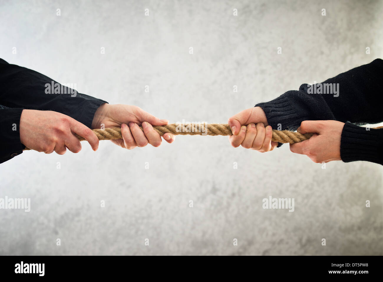 female hands pulling rope to opposite sides. Rivalry concept. Stock Photo