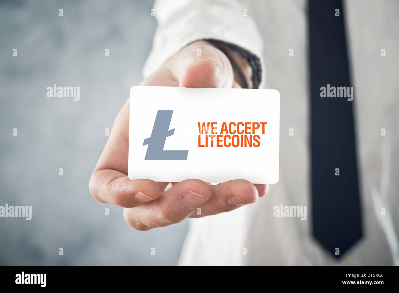 Businessman holding card with title WE ACCEPT LITECOINS. Selective focus on card and fingers. Stock Photo