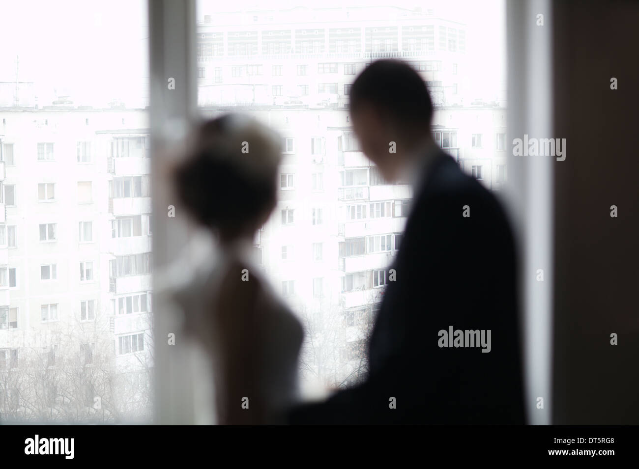 Bridal pair looking out the window Stock Photo