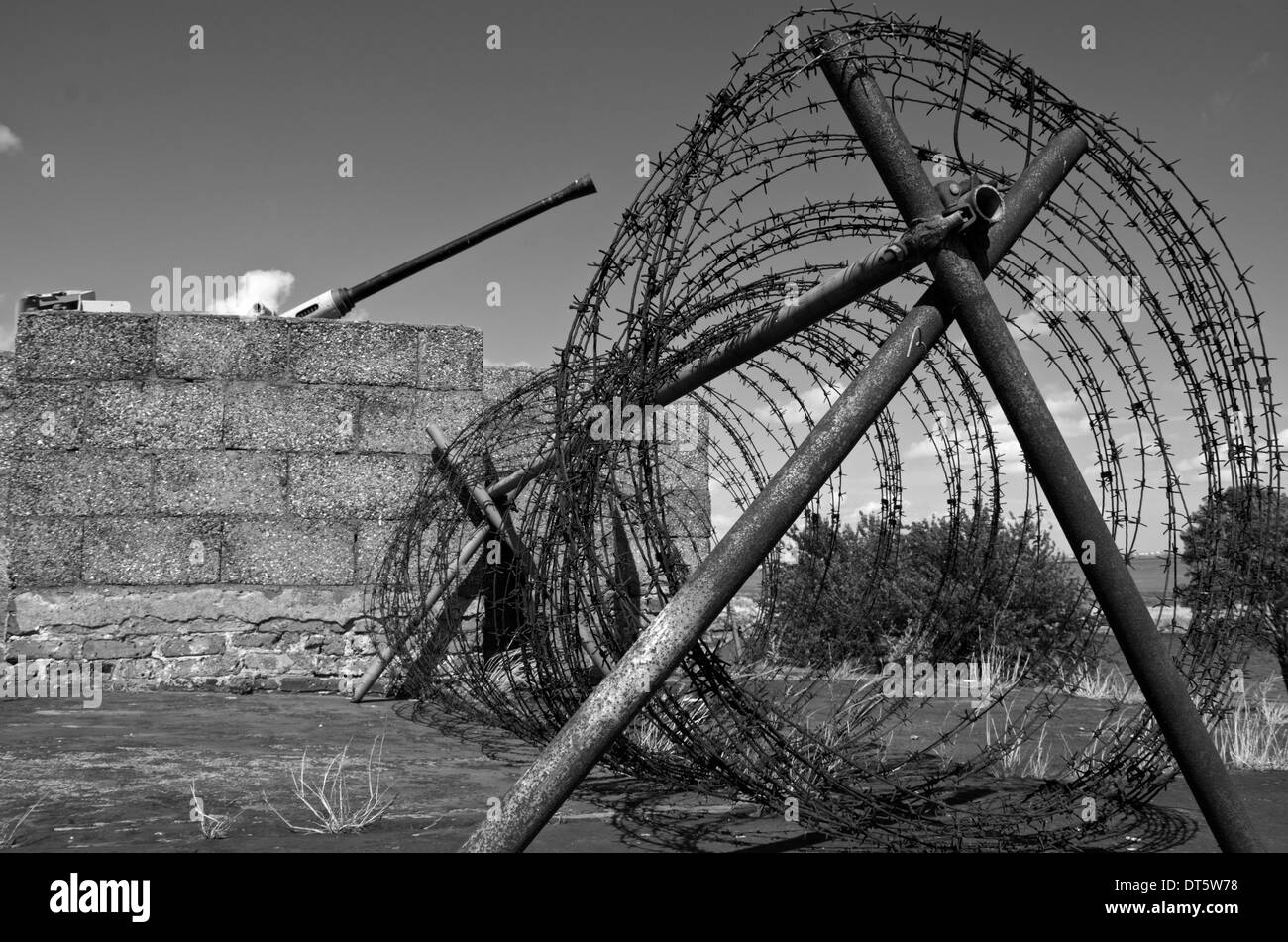 Coiled barbed wire on a gun emplacement. Black and white image. Stock Photo