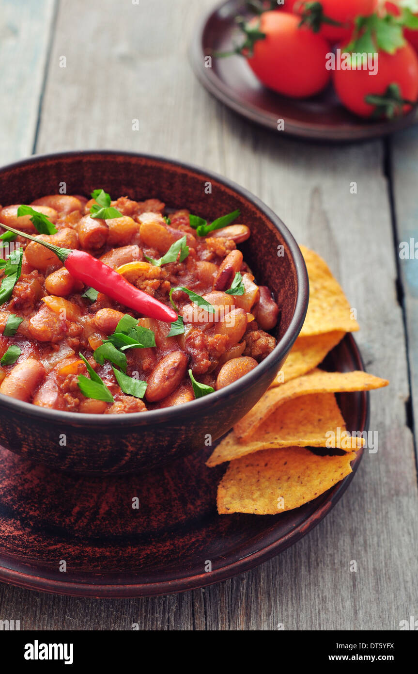 Chili Con Carne in bowl with tortilla chips on wooden background Stock Photo
