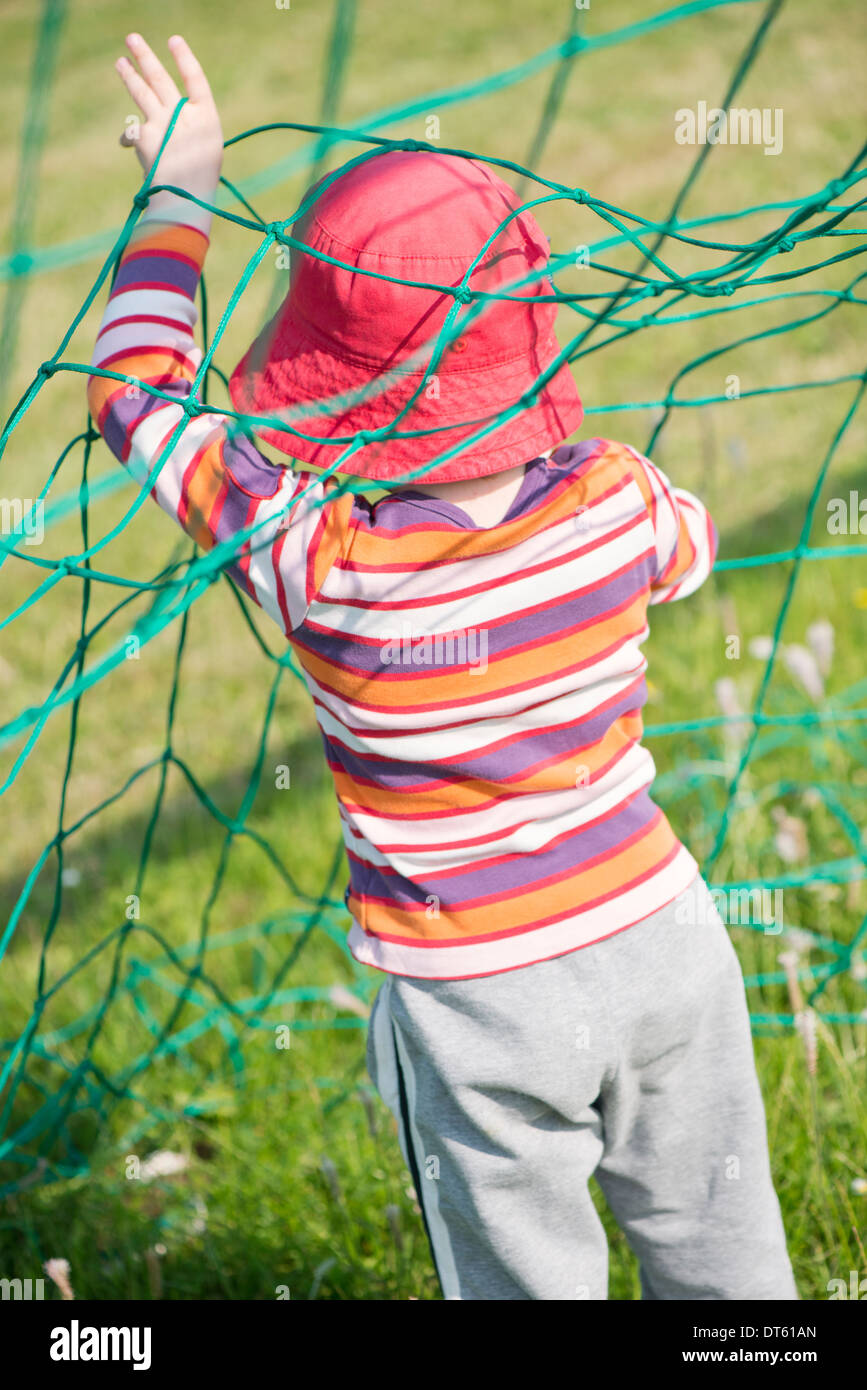 Young girl playing with net of football (soccer) goal Stock Photo