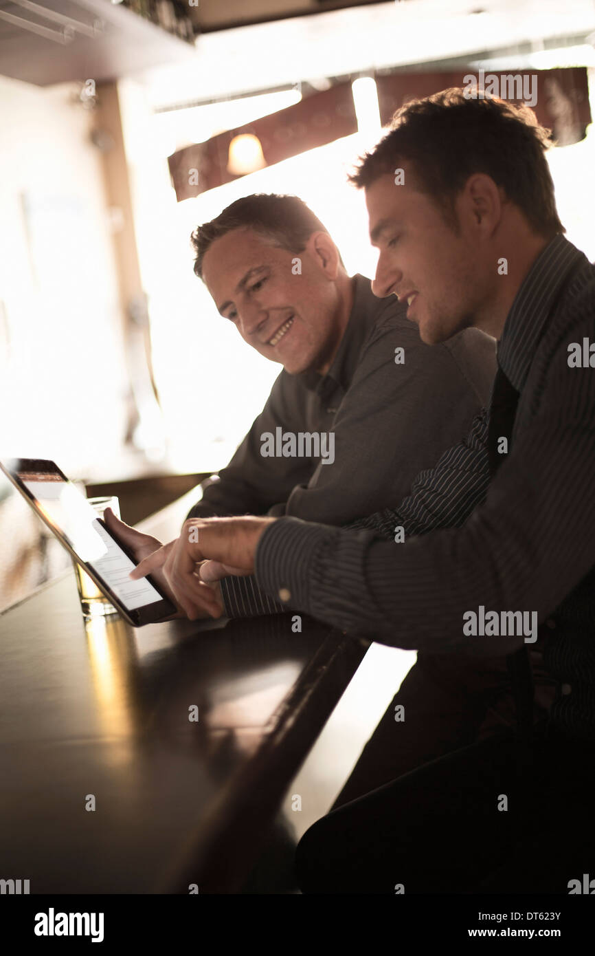 Two businessmen looking at digital at the bar Stock Photo