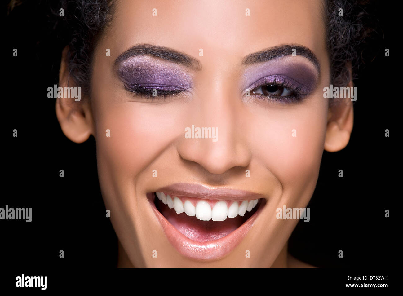 Close up studio portrait of young woman winking Stock Photo
