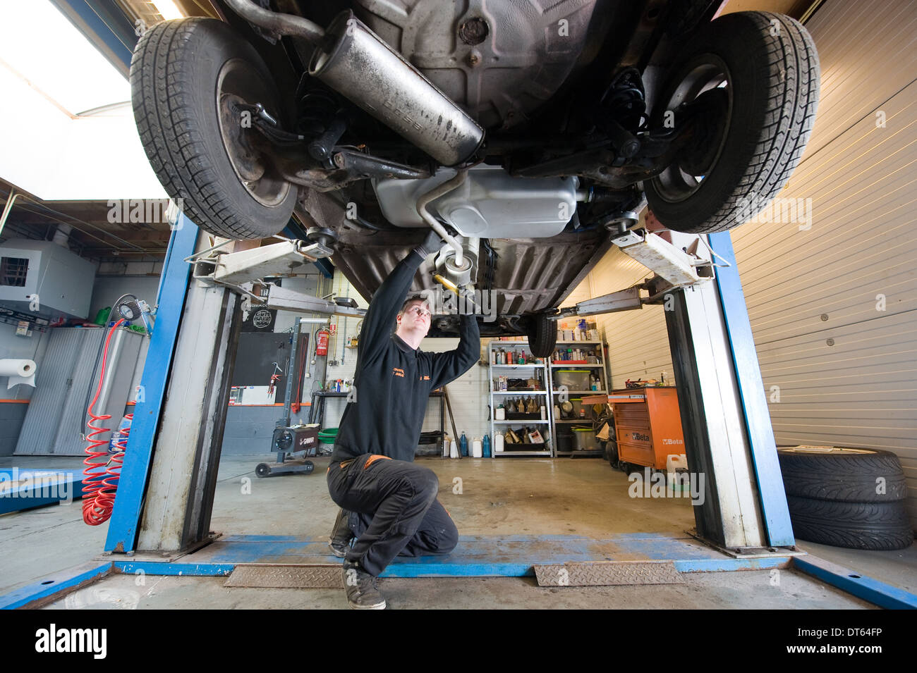 A mechanic is working on a car in a garage Stock Photo