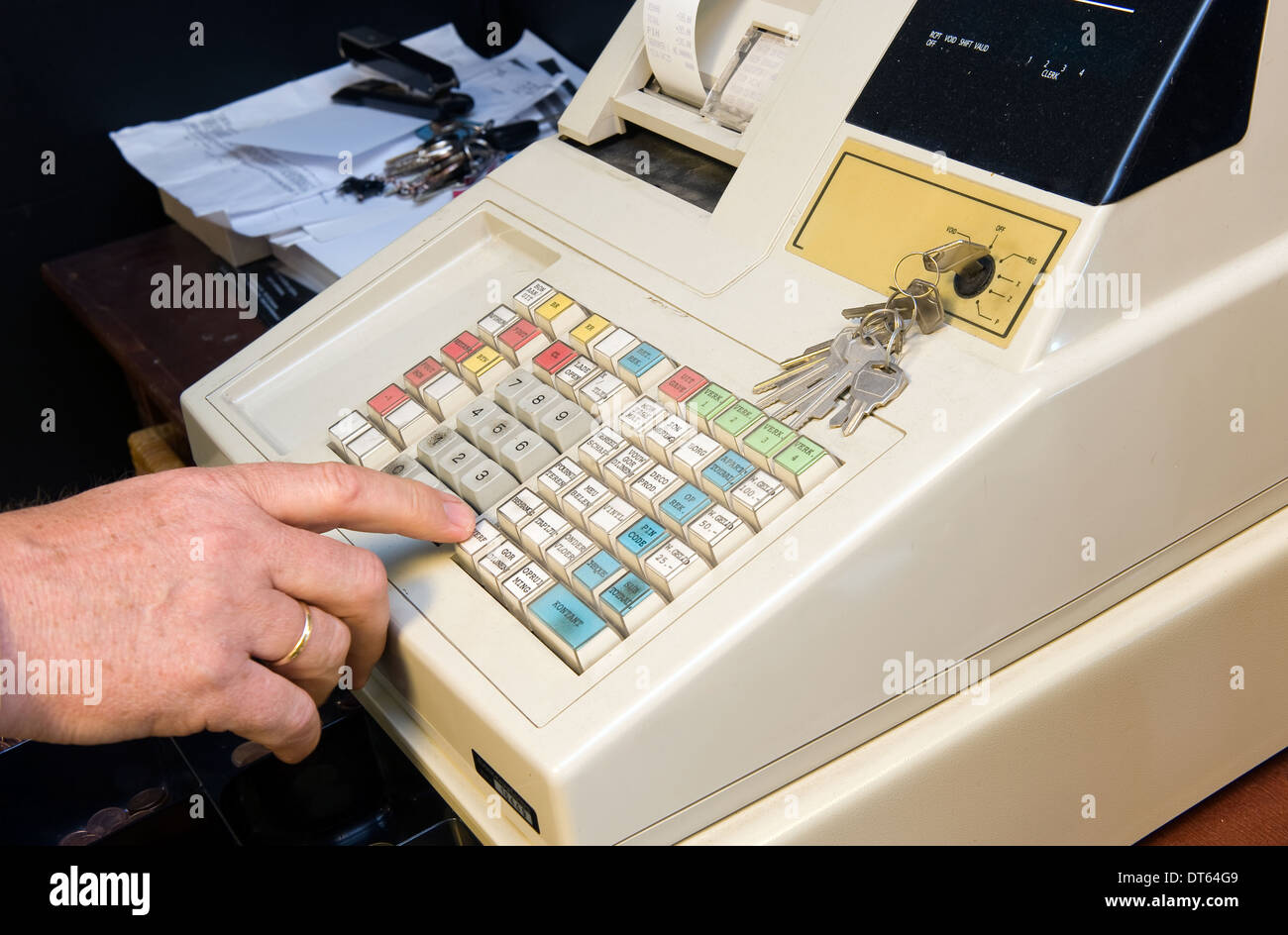 A salesman in a shop is opening his cash register Stock Photo