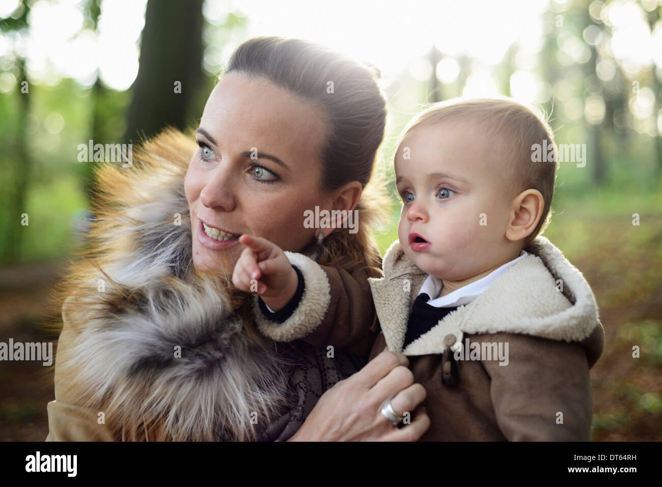 Mother holding male toddler in woodland park Stock Photo