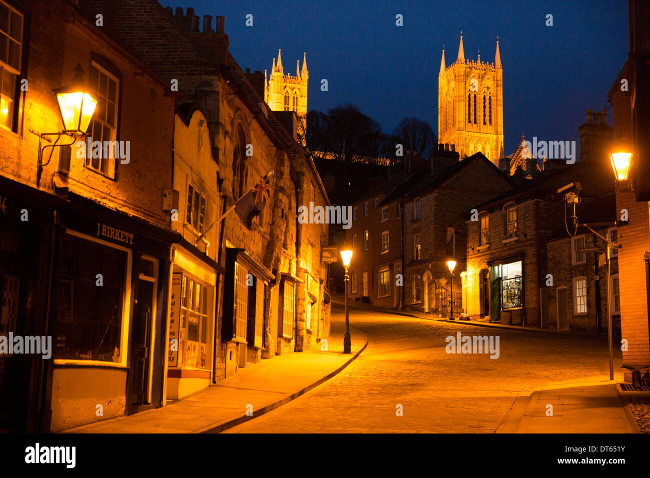 The view of Lincoln Cathedral from the High Street looking up Steep Hill photographed at evening time. Stock Photo