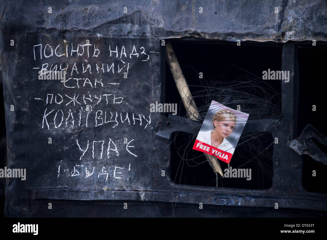 An image of Yulia Tymoshenko with poetry words on one of the burnt out buses at the Euromaidan protester barricades in Kiev. Stock Photo
