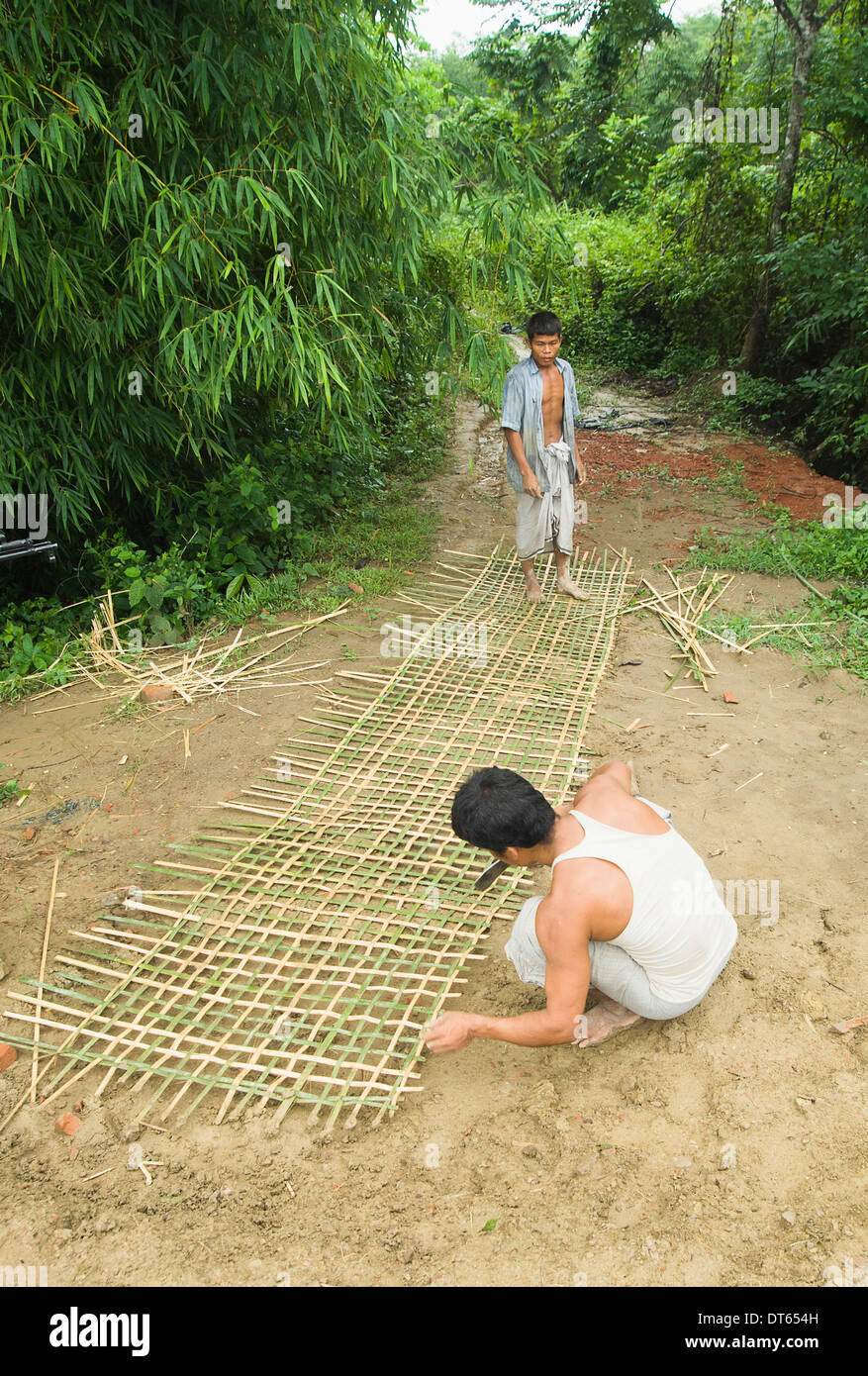Bangladesh, South Asia, Chittagong Hills, Khagrachari, Two men weaving a large bamboo fence panel. Stock Photo
