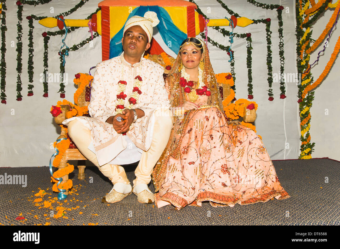 Bangladesh, Dhaka, Muslim bride and groom dressed up in glitzy jewellery and flowers for their wedding. Stock Photo