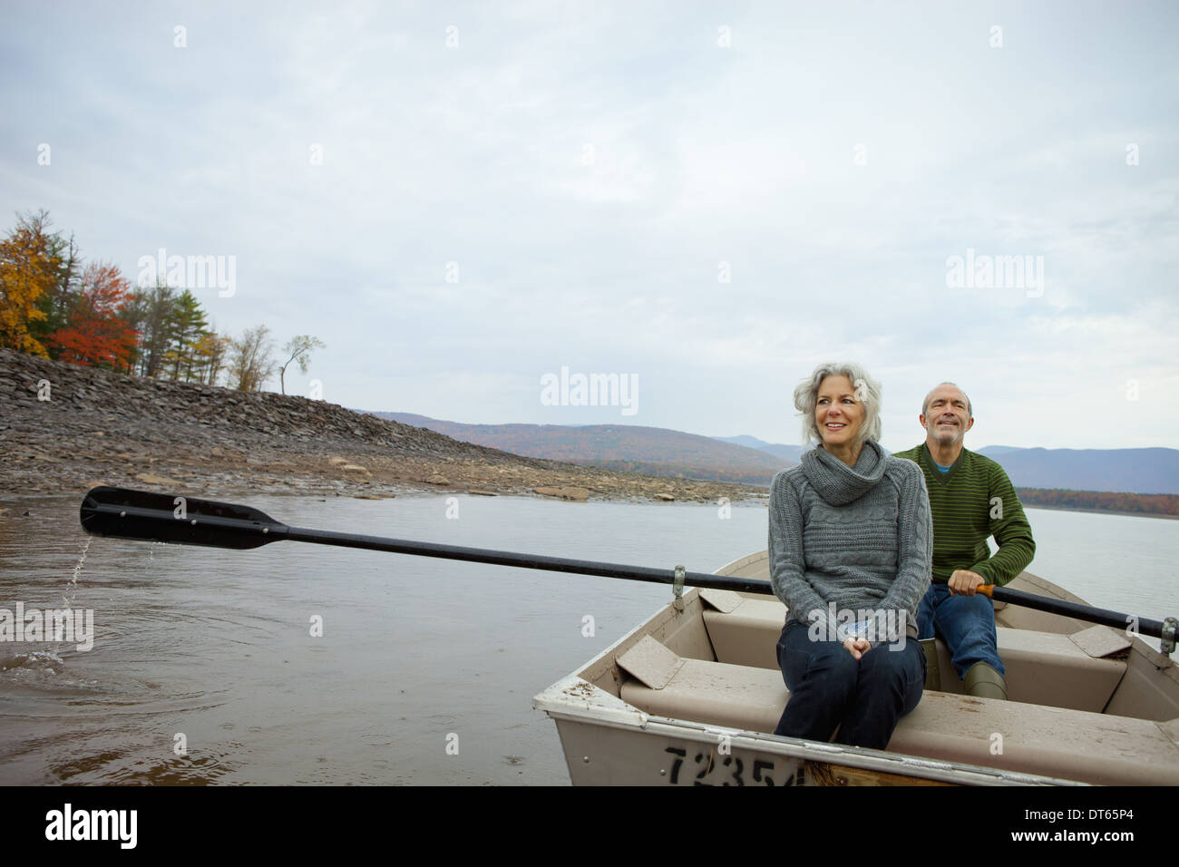 A couple, man and woman sitting in a rowing boat on the water on an ...