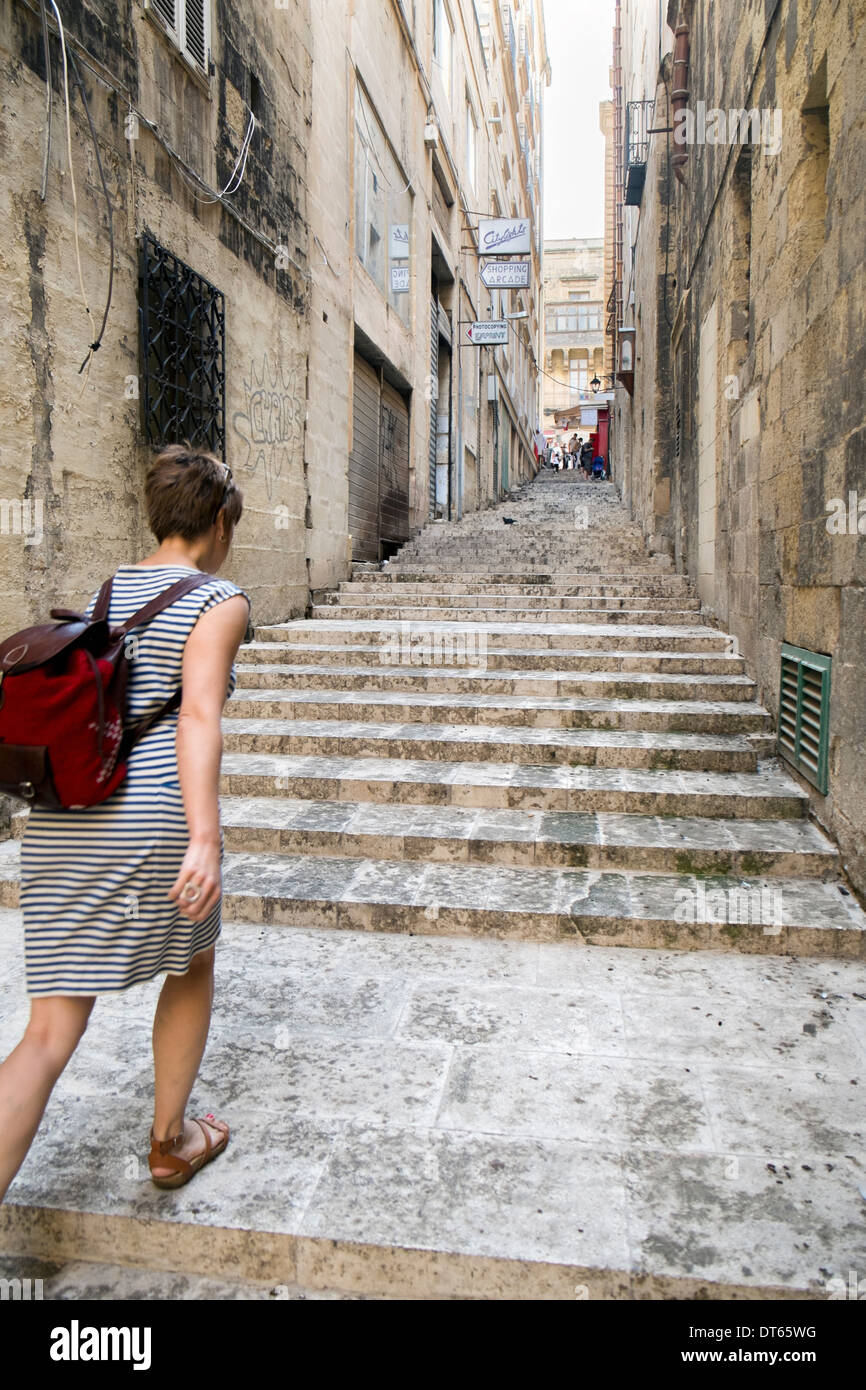 Female tourist walking up stairs, Valletta, Malta Stock Photo