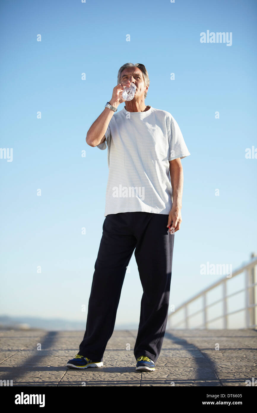 Senior man drinking water on walk Stock Photo