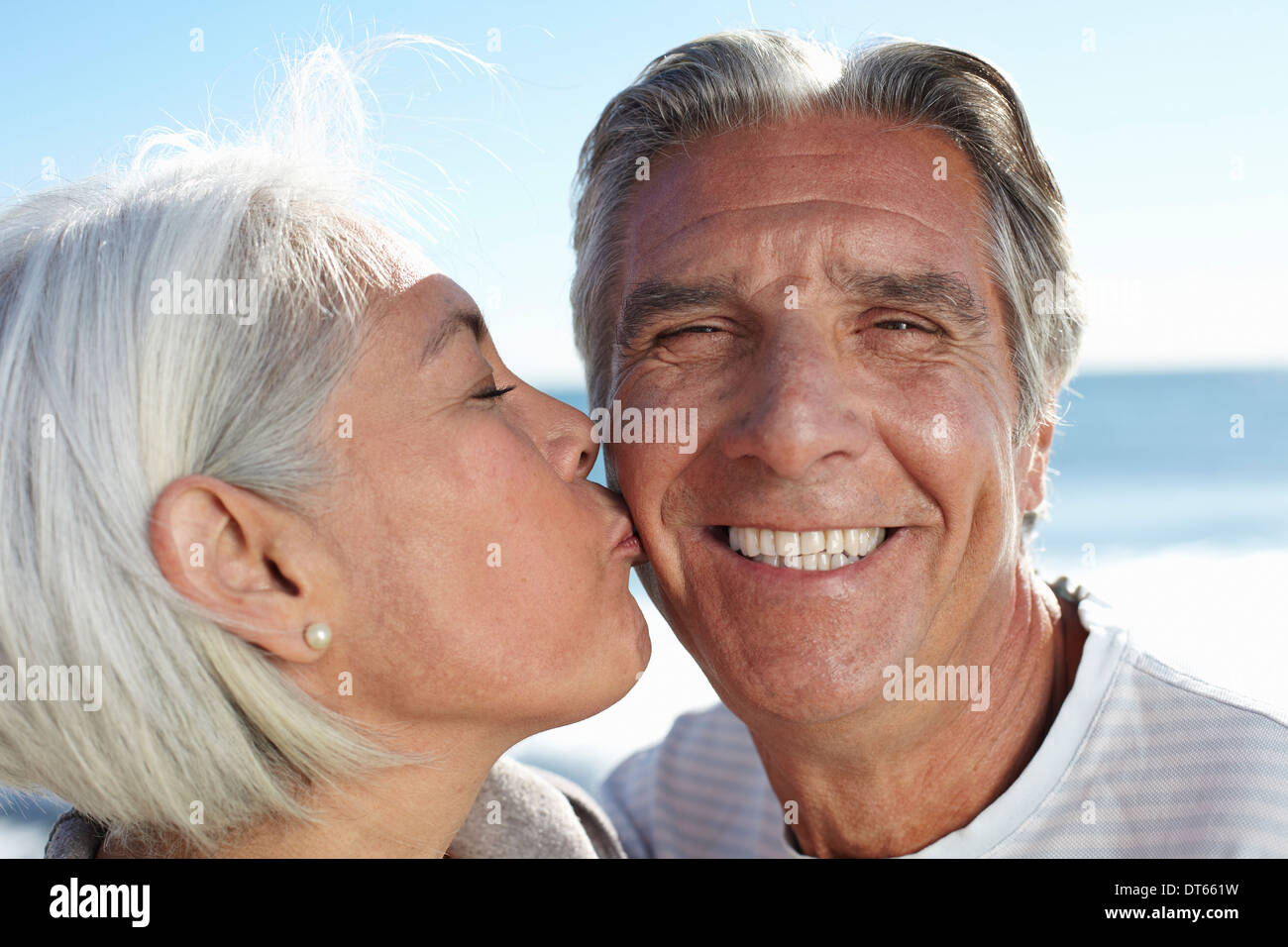 Woman pecking man on cheek Stock Photo