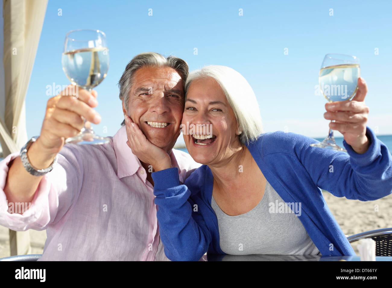 Couple enjoying wine by seaside Stock Photo