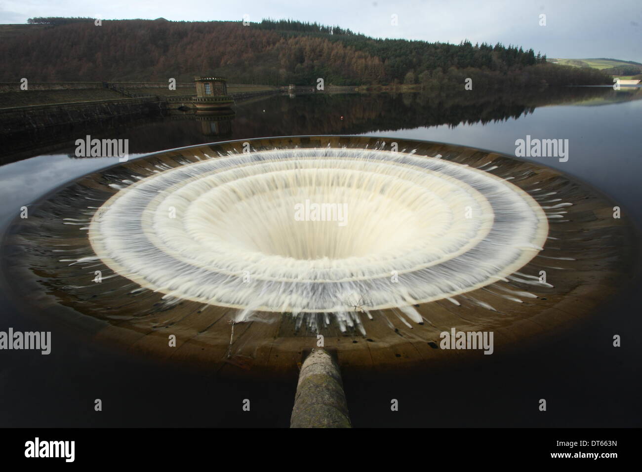 Thoudands of gallons of overflow water plunges down a bellmouth spillway shaft in Ladybower Reservoir, Upper Derwent Valley, Peak District Derbyshire UK Stock Photo