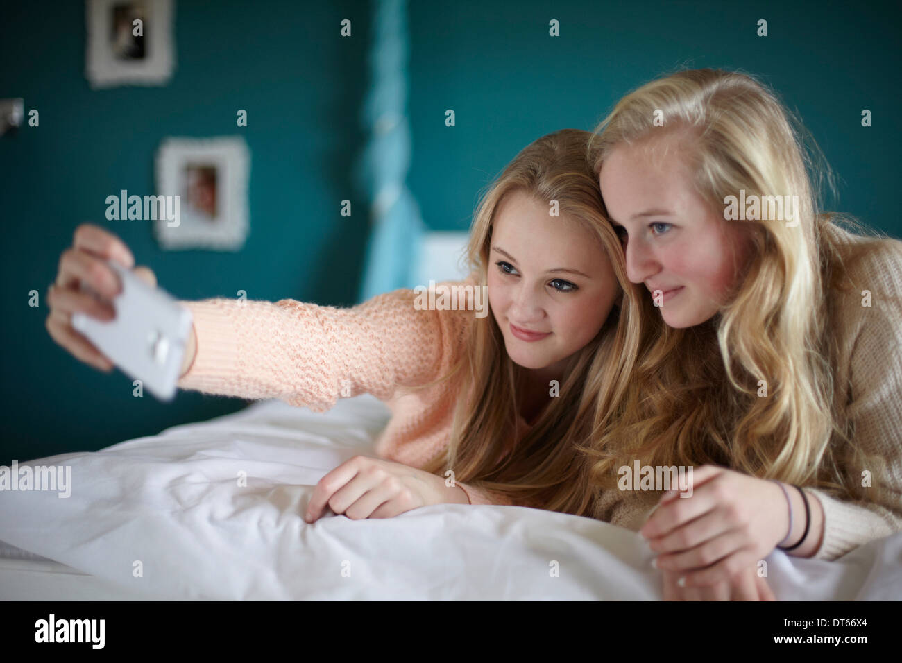 Two teenage girls taking selfie in bedroom Stock Photo - Alamy
