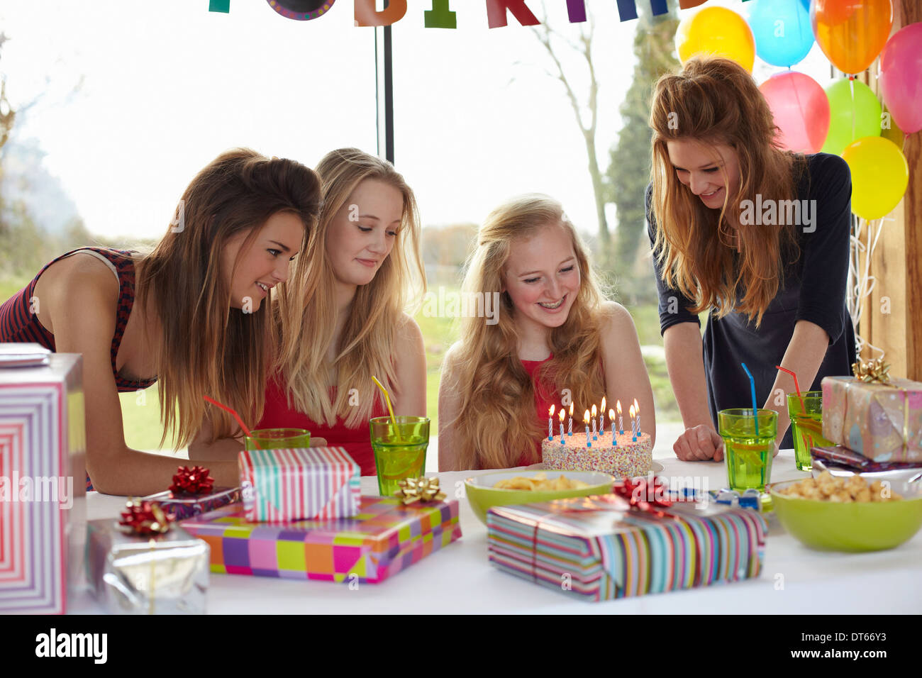 Teenage girl sharing birthday cake with friends Stock Photo