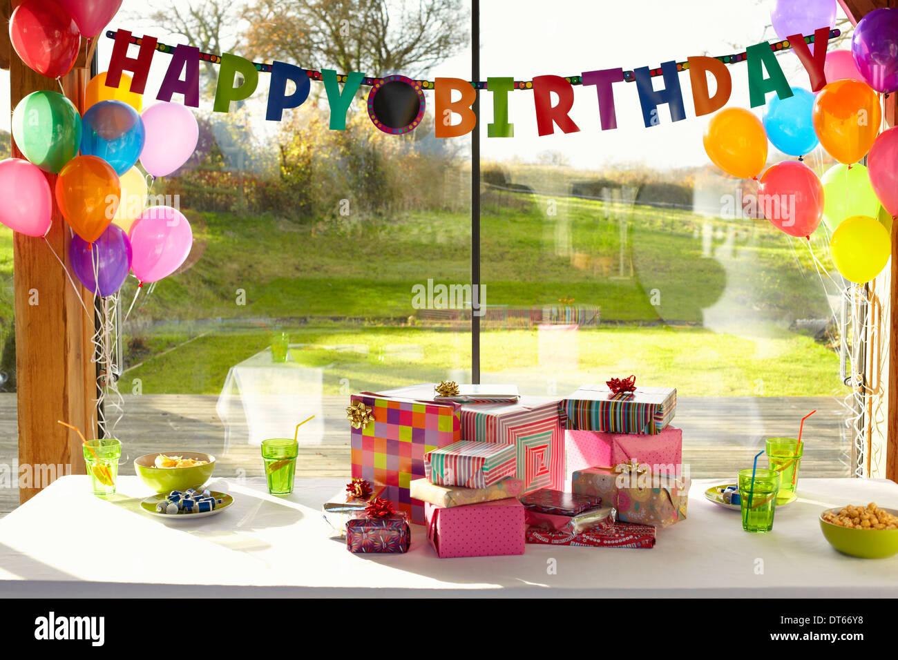 Table laid with birthday gifts and balloons Stock Photo