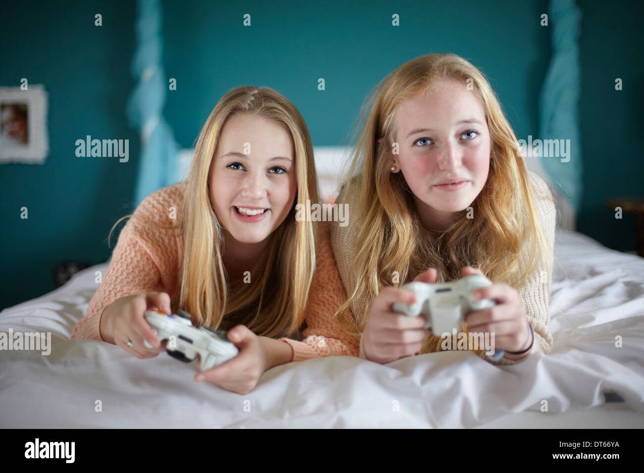 Two teenage girls playing on computer game in bedroom Stock Photo