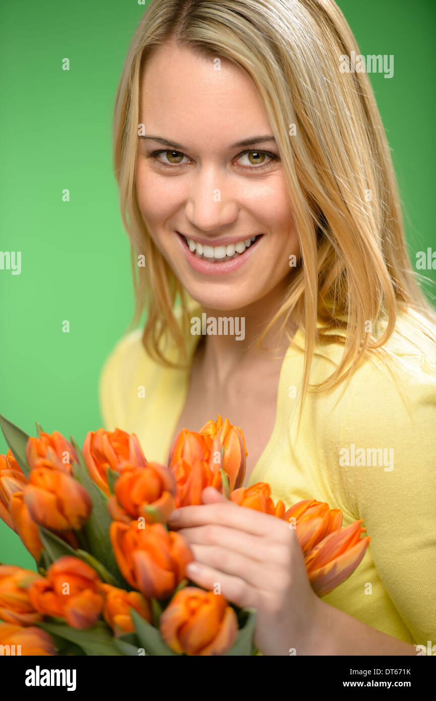 Smiling woman hold spring flowers bouquet of orange tulips Stock Photo