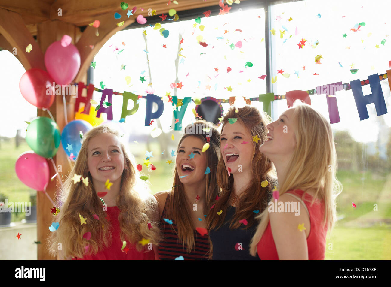 Four teenage girls enjoying confetti at birthday party Stock Photo