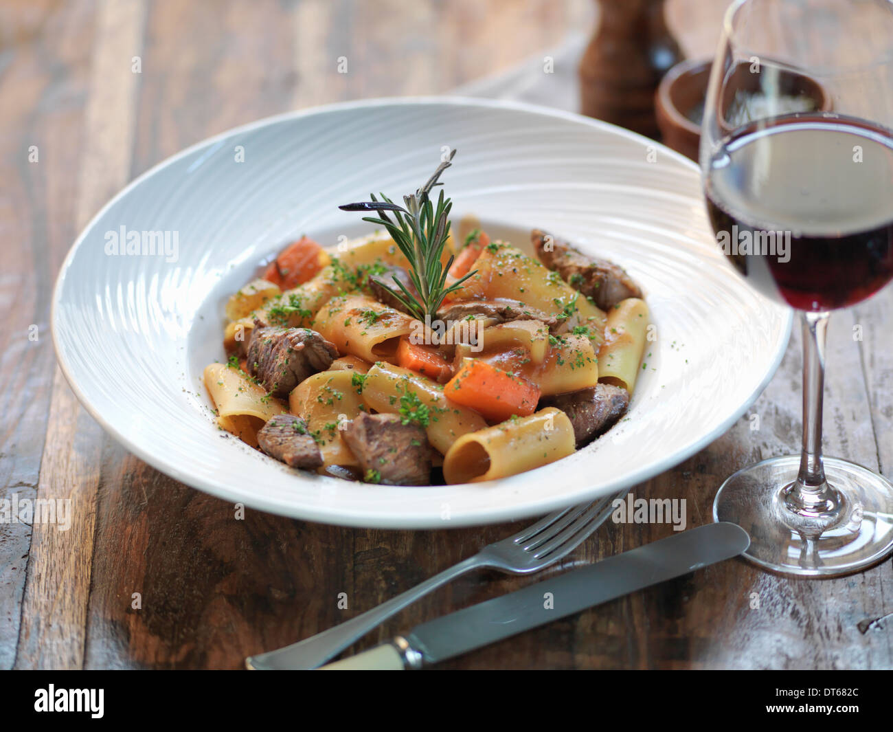Paccheri pasta with slow cooked ox cheek, fresh rosemary, garlic, bay leaves, tomato and red wine Stock Photo