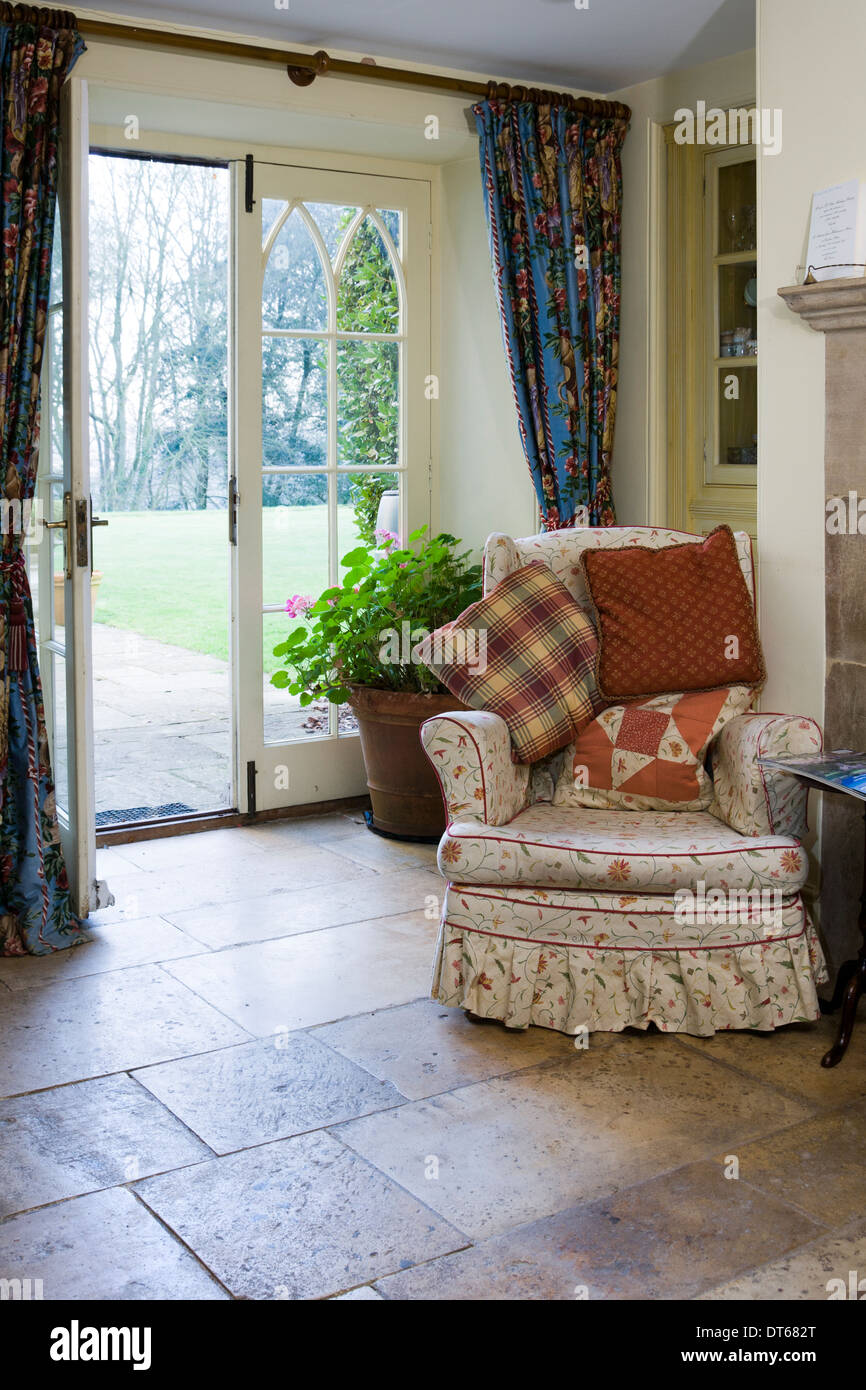 Cosy kitchen armchair by an open garden door. Stock Photo