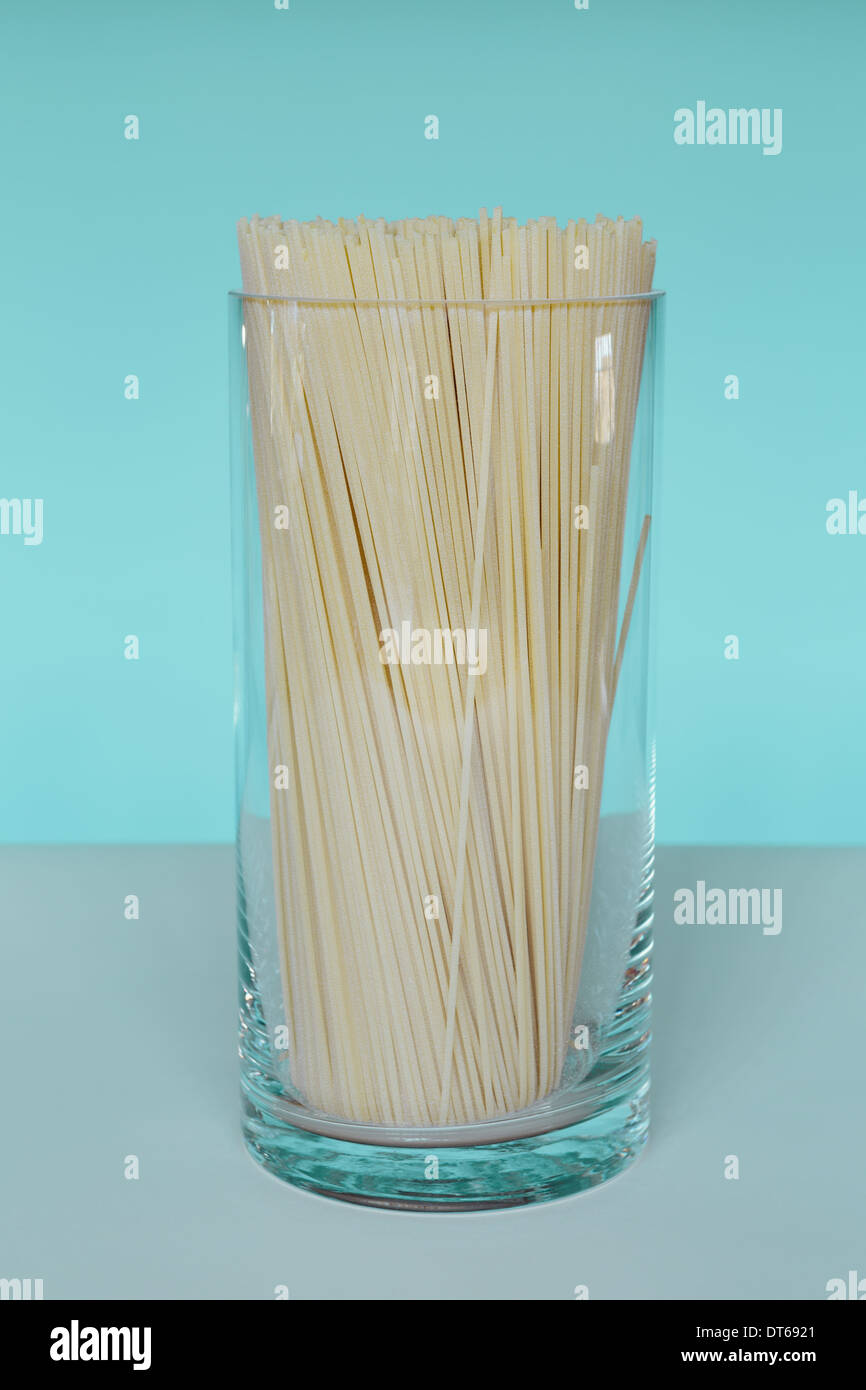 Uncooked organic pasta noodles in glass vase. Spaghetti noodles made of
