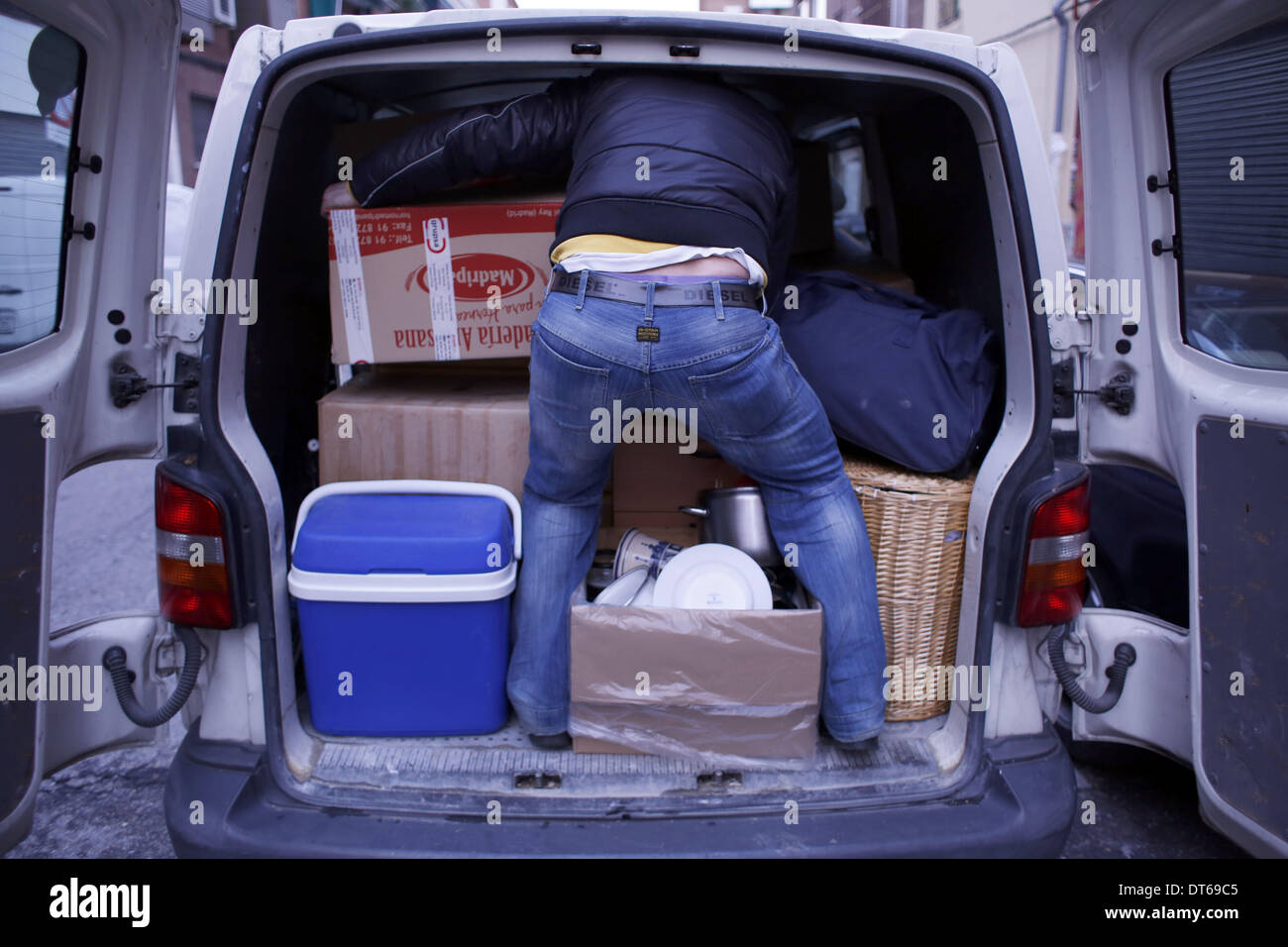 Madrid, Spain. 10th Feb, 2014. 30 year-old Iban Labici places carefully his belongings inside his van as he waits to be evicted from his home in Madrid, Spain, Monday, Feb. 10th 2014. 30 year-old Iban Labici, with his partner 29 year-old Lavinia Uta from Romania were evicted from their previous home owned by '' La Caixa'' in 2010 when they lost their jobs due to the financial crisis. Iban's brother, 38 year-old Mihail Labici offered them one of his two homes whose mortgages were contracted with Banco Sabadell. 38 year-old Mihail Labici in the past led a construction company that went bankrupt Stock Photo