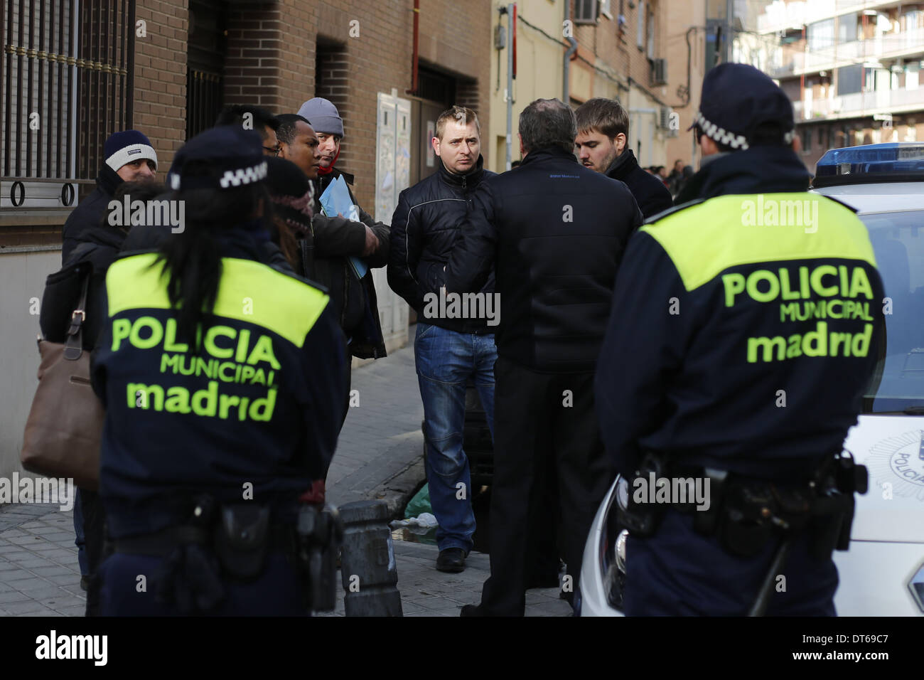 Madrid, Spain. 10th Feb, 2014. 30 year-old Iban Labici (middle) negotiates with the judicial commission as he waits to be evicted from his home in Madrid, Spain, Monday, Feb. 10th 2014. 30 year-old Iban Labici, with his partner 29 year-old Lavinia Uta from Romania were evicted from their previous home owned by '' La Caixa'' in 2010 when they lost their jobs due to the financial crisis. Iban's brother, 38 year-old Mihail Labici offered them one of his two homes whose mortgages were contracted with Banco Sabadell. 38 year-old Mihail Labici in the past led a construction company that went bankru Stock Photo