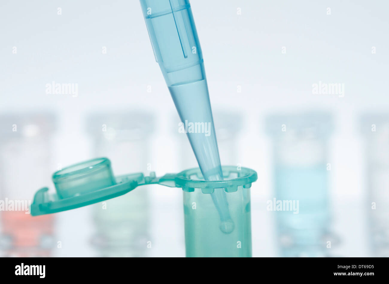 Still life of micropipette pipetting liquid into microcentrifuge tube