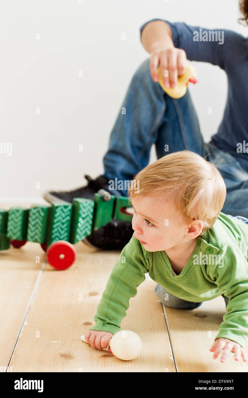 Studio shot of father and baby daughter playing on floor Stock Photo