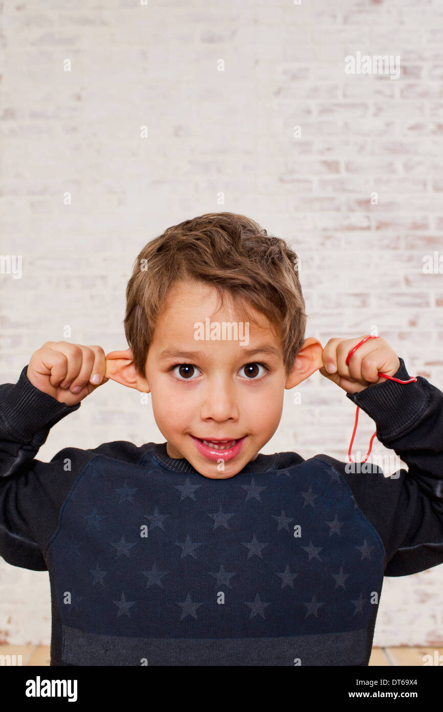 Studio portrait of boy pulling his ears Stock Photo