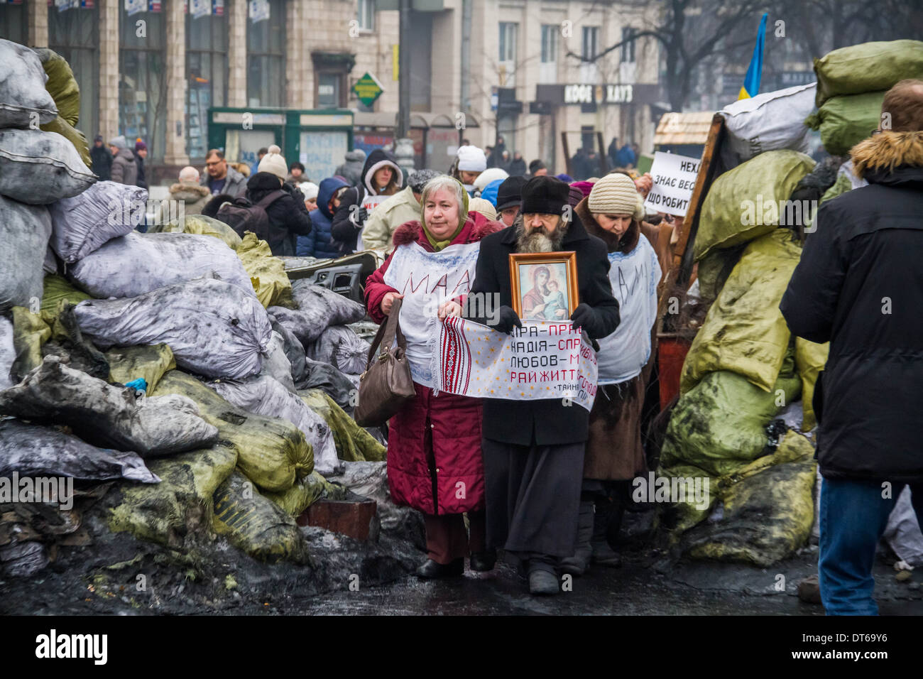 An Orthodox priest with icons and local mothers (‘MAMA’) walk through ...