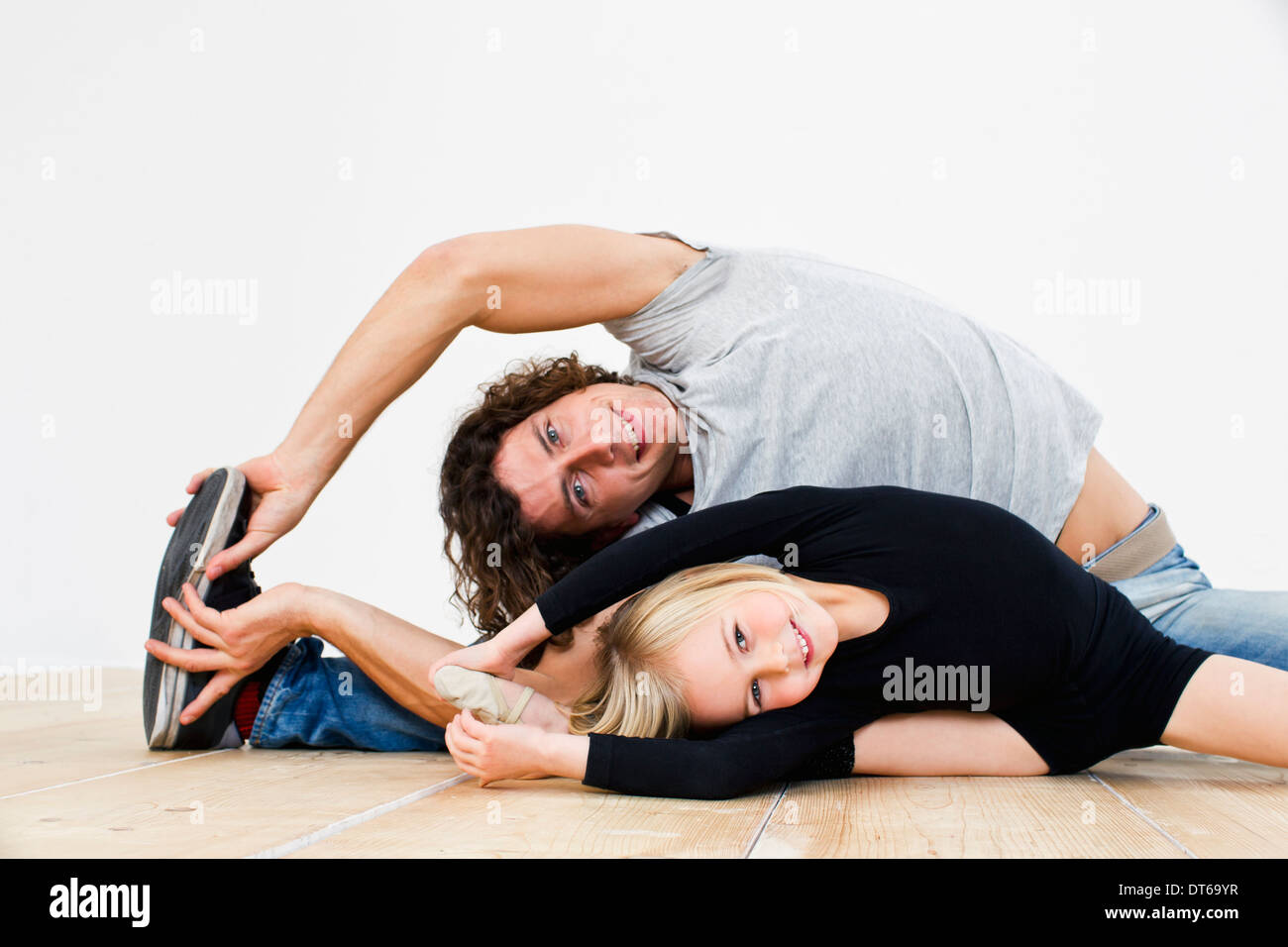 Studio shot of father and ballerina daughter doing splits Stock Photo