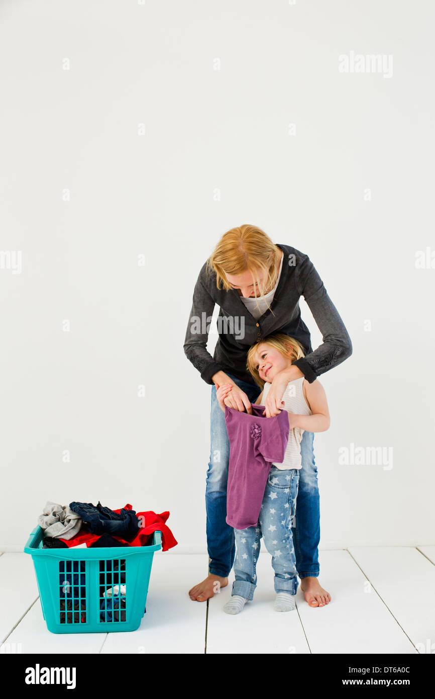 Studio shot of mother and daughter with dirty laundry Stock Photo