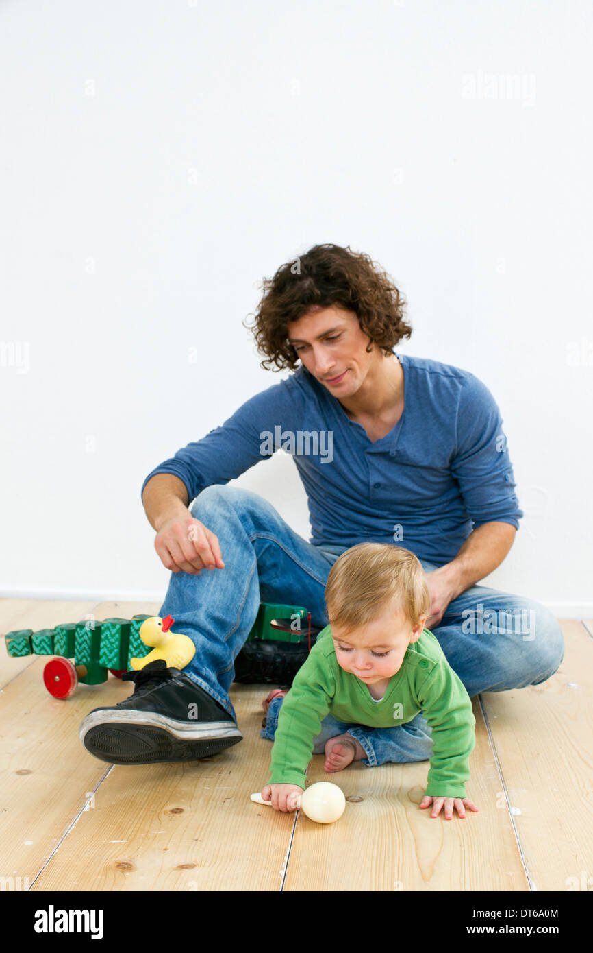 Studio shot of father and baby daughter paying on floor Stock Photo