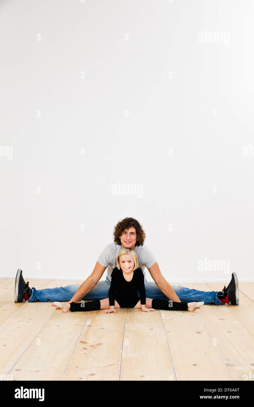 Studio portrait of father and ballerina daughter doing splits Stock Photo