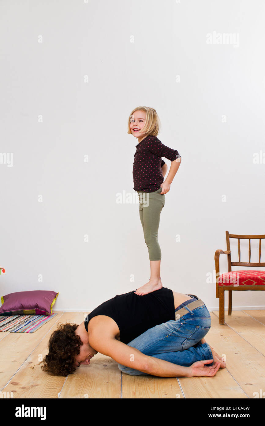 Studio shot of daughter standing on top of father Stock Photo