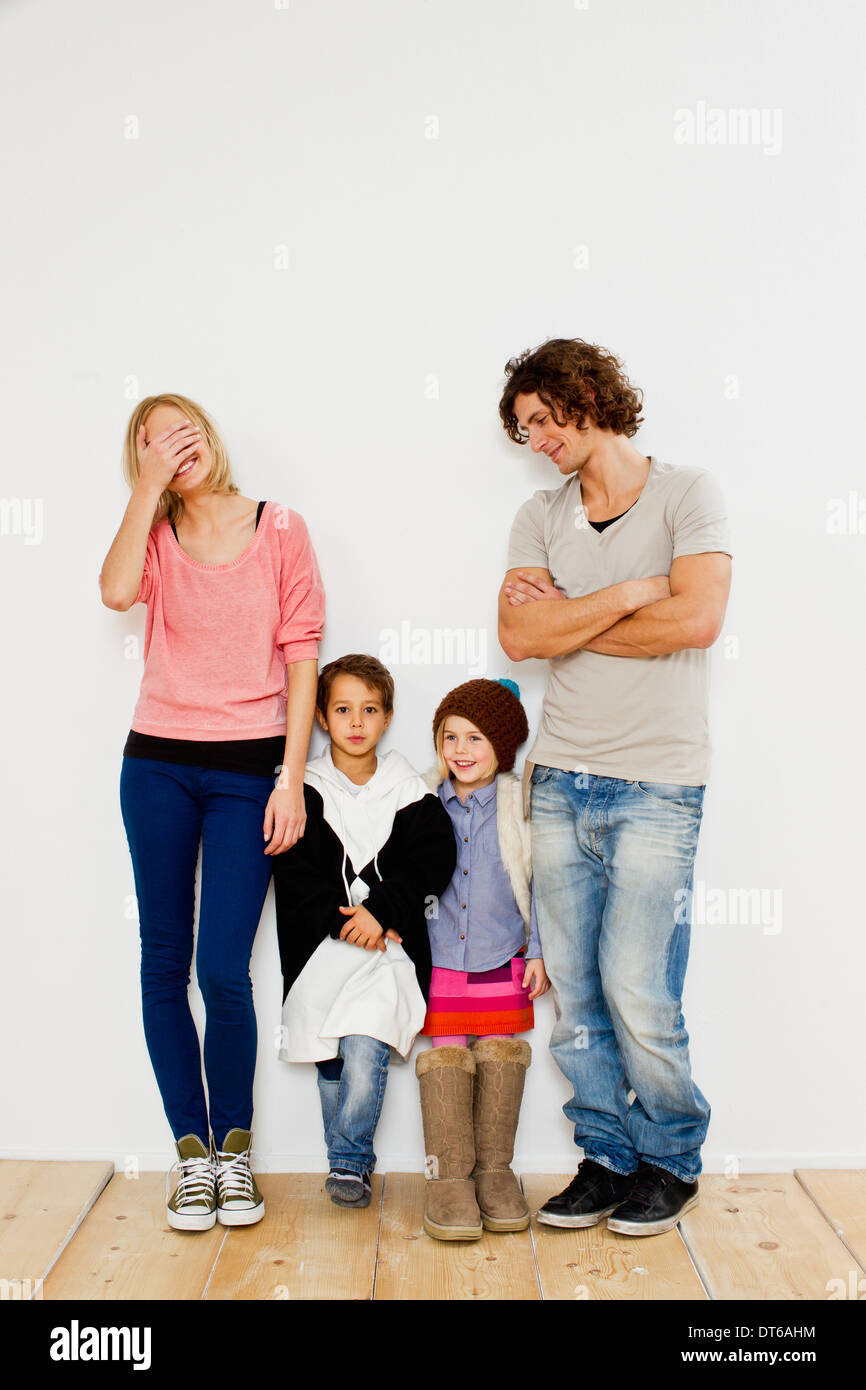 Studio shot of couple with son and daughter in oversize clothes Stock Photo