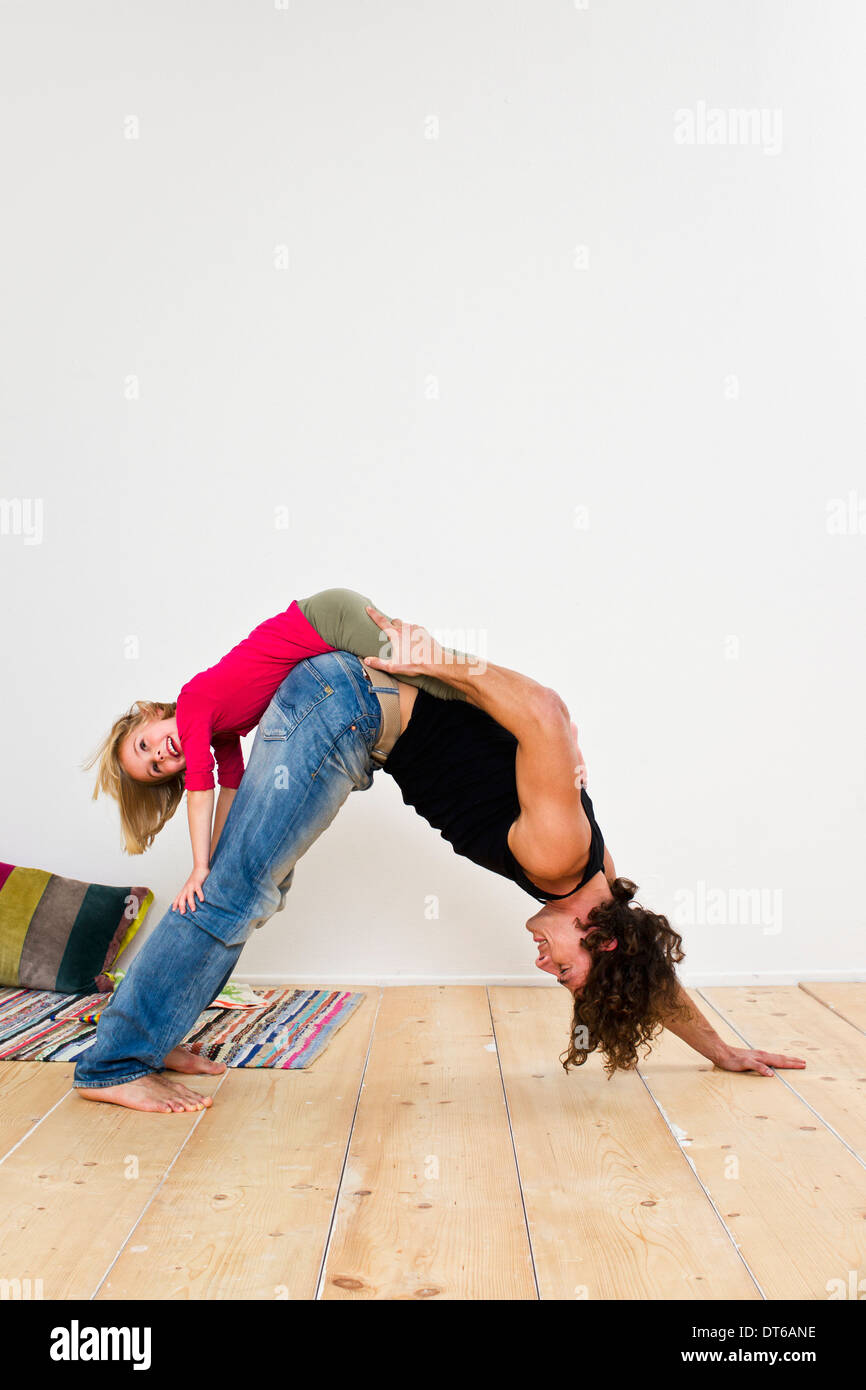 Studio shot of father with daughter bending over on floor Stock Photo