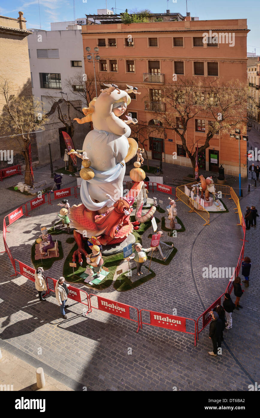 Spain, Valencia, Papier Mache falla scene with people by giant figure of lady in street at Torres de Quart during Las Fallas. Stock Photo