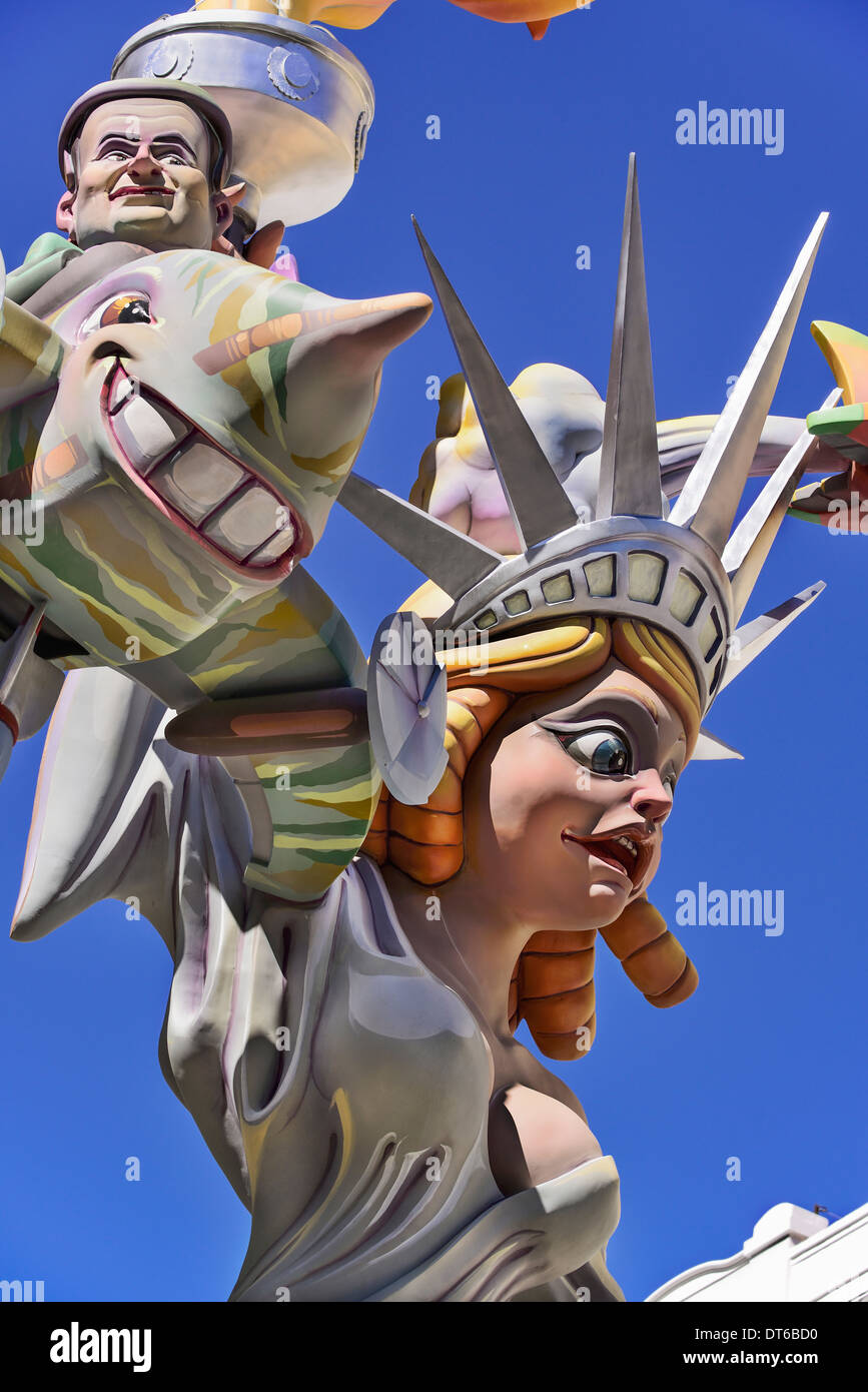 Spain, Valencia, Papier Mache figure of woman resembling Statue of Liberty holding a figure flying around her during Las Fallas. Stock Photo