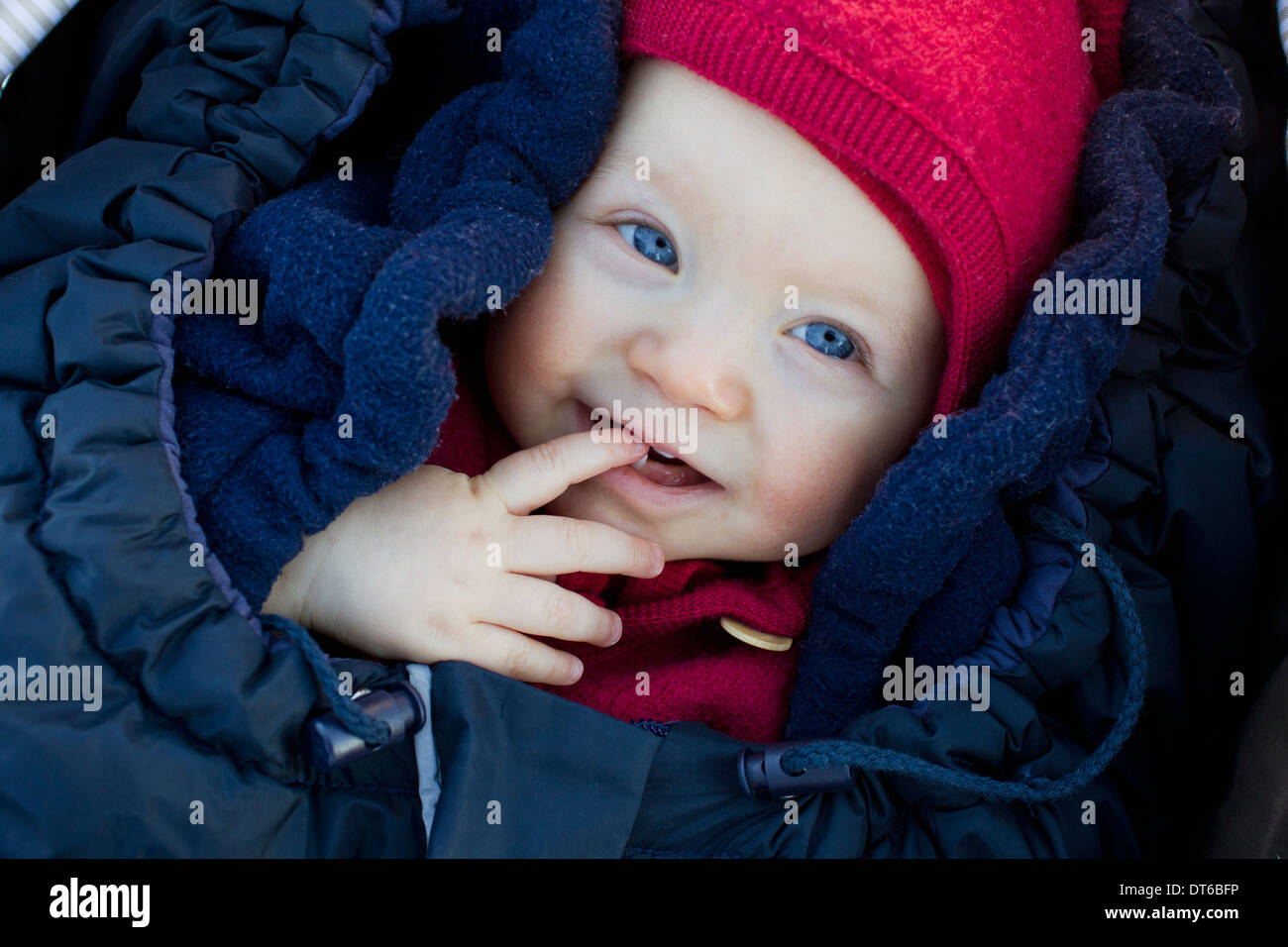 Portrait of baby girl in sleeping bag wearing hat Stock Photo