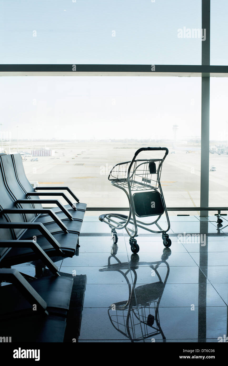 Empty airport departure lounge and suitcase trolley Stock Photo